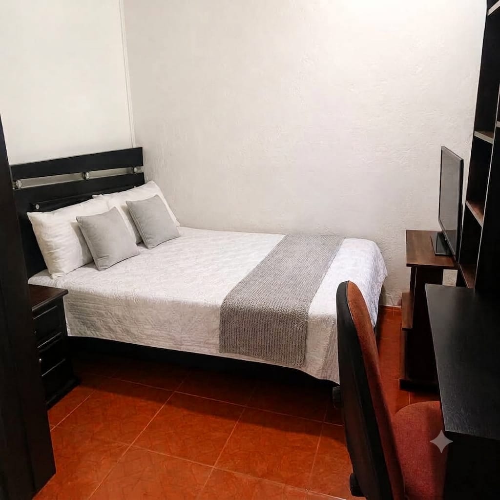 Habitación Urban Plus con cama y zona de escritorio en madera.