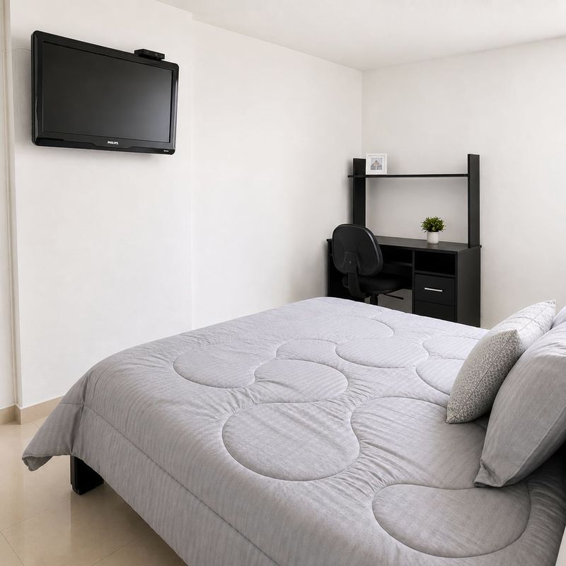 Prime: cama, televisor y escritorio con estantería.